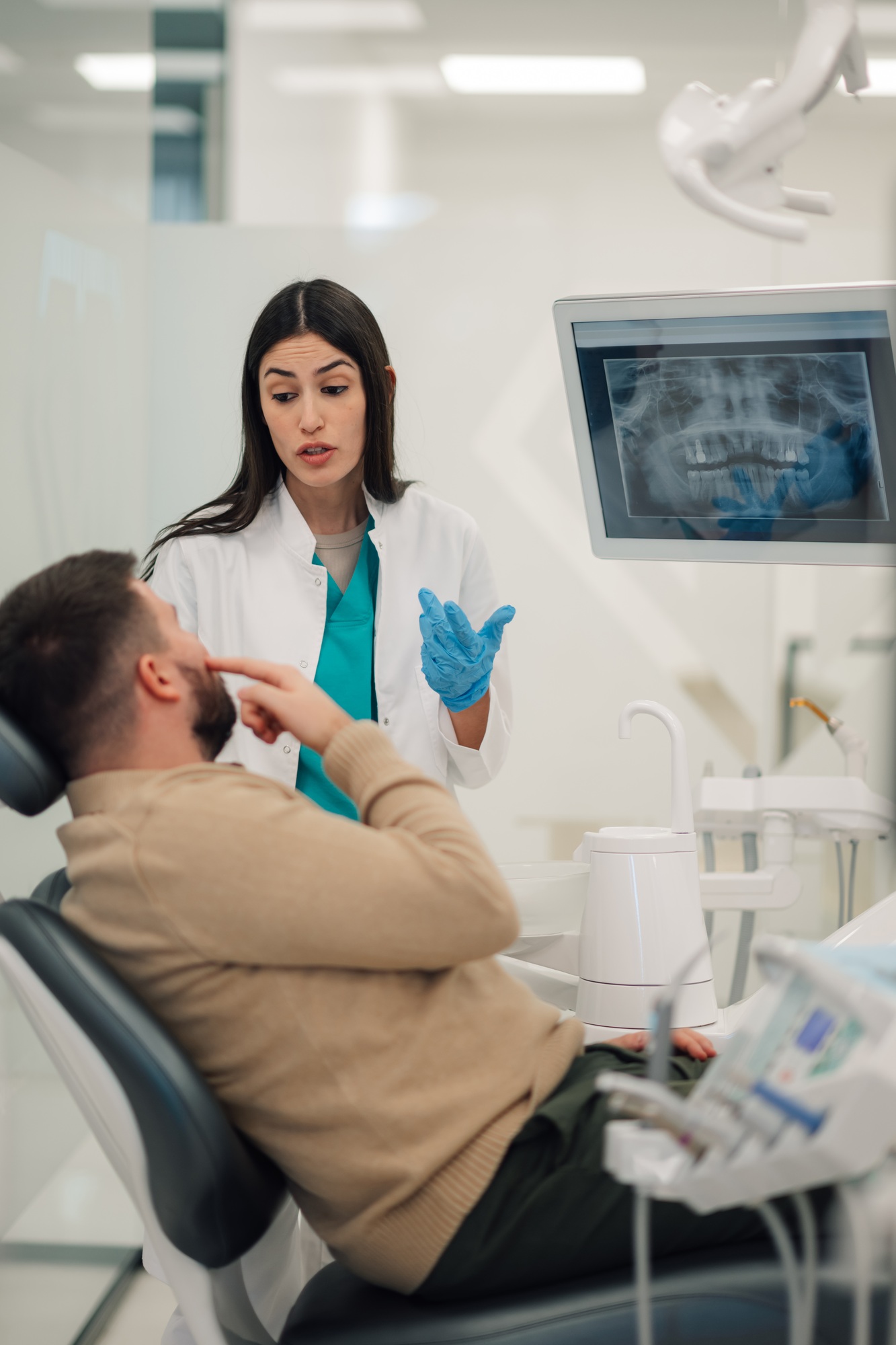 Female dentist explaining dental x ray to patient in clinic